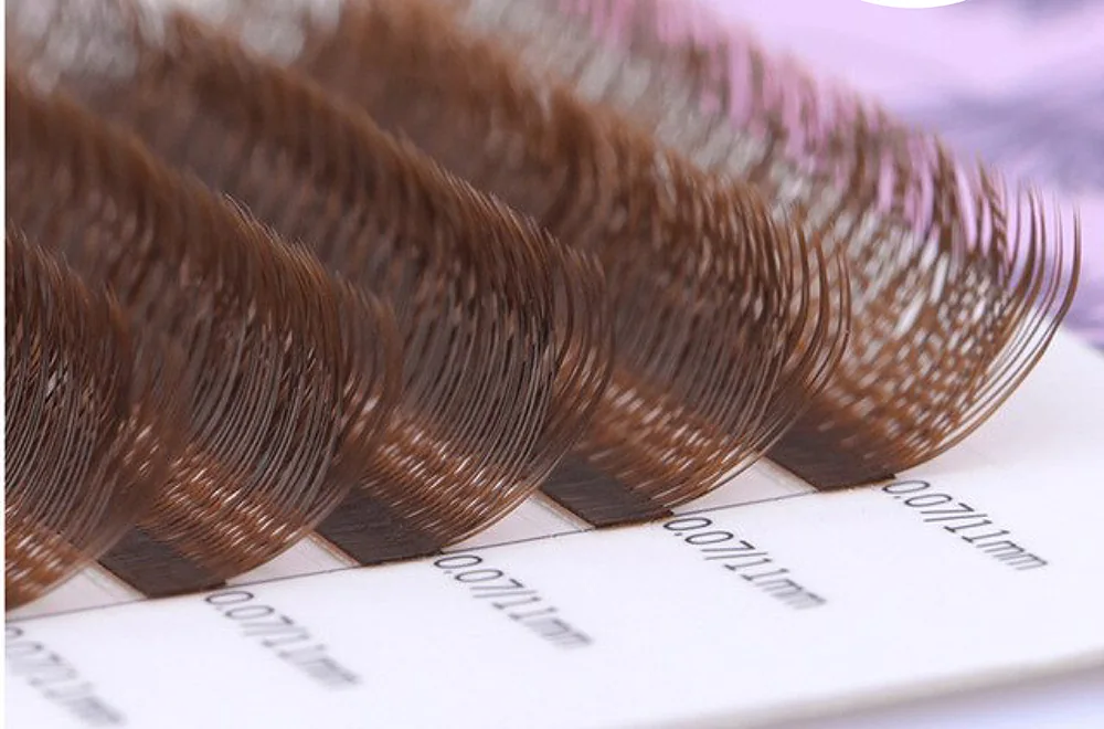 Close-up of brown lash extensions on a 0.07 mm tray row