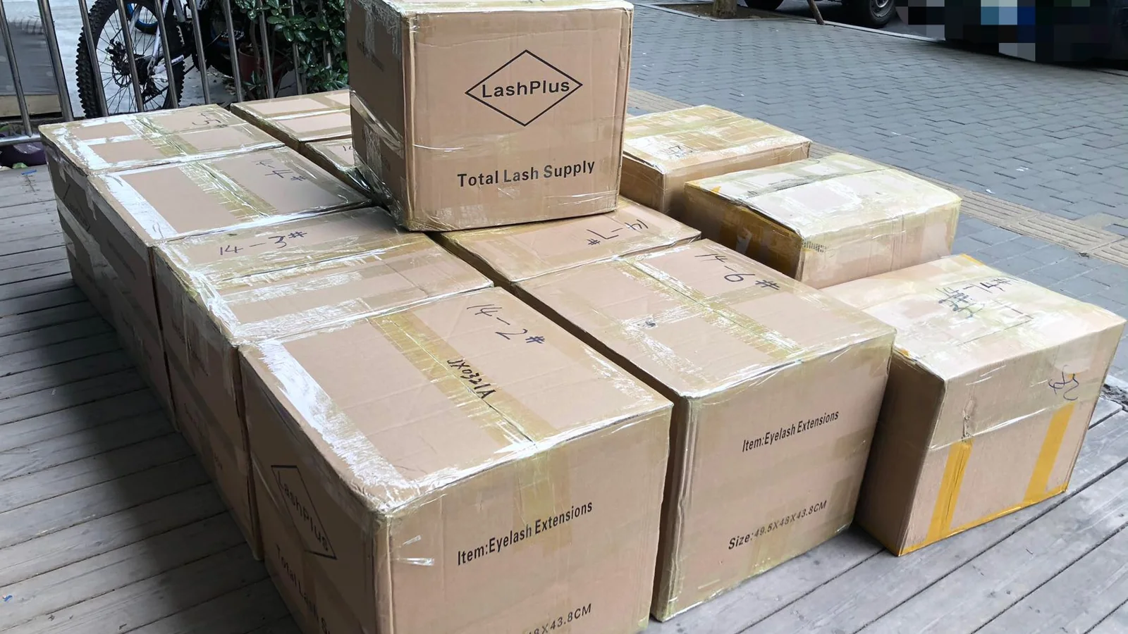 Packed LashPlus export cartons stacked and wrapped, leaving the factory in Pingdu