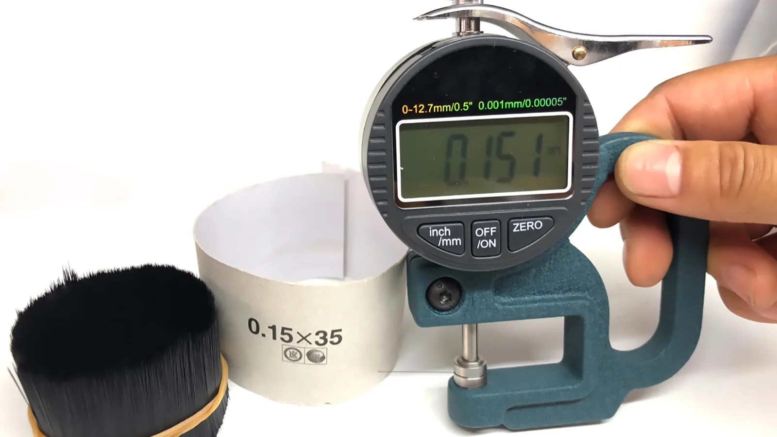 Digital gauge reading 0.151 mm on an incoming lash fiber bundle marked 0.15 x 35