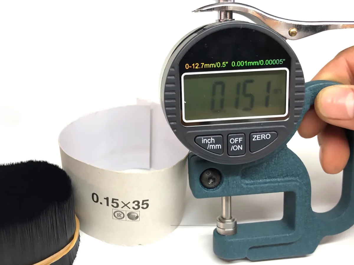 Digital gauge reading 0.151 mm on a flat lash row during a batch check