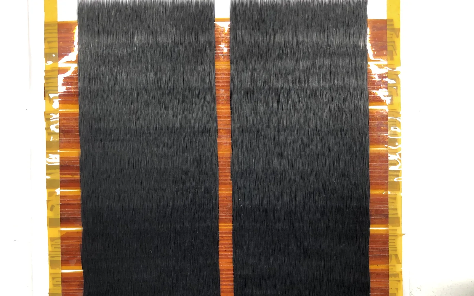 A taped band of lash fiber with the batch spec 0.15 10 mm 100 pcs written on the tape