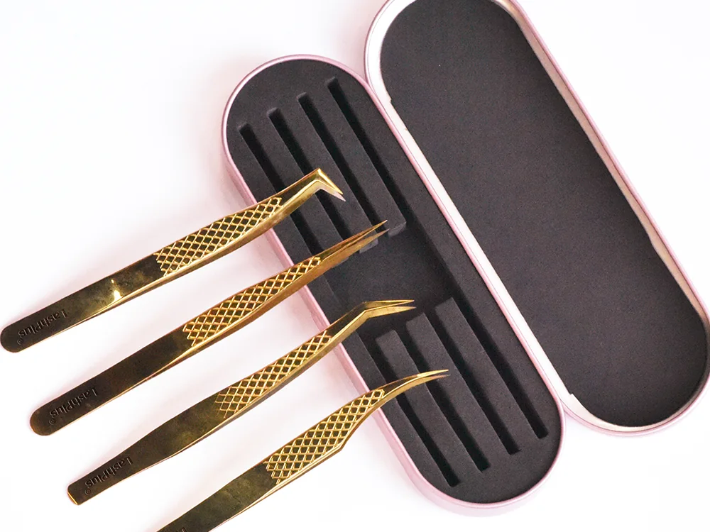 Gold LashPlus lash extension tweezers seated in their magnetic case
