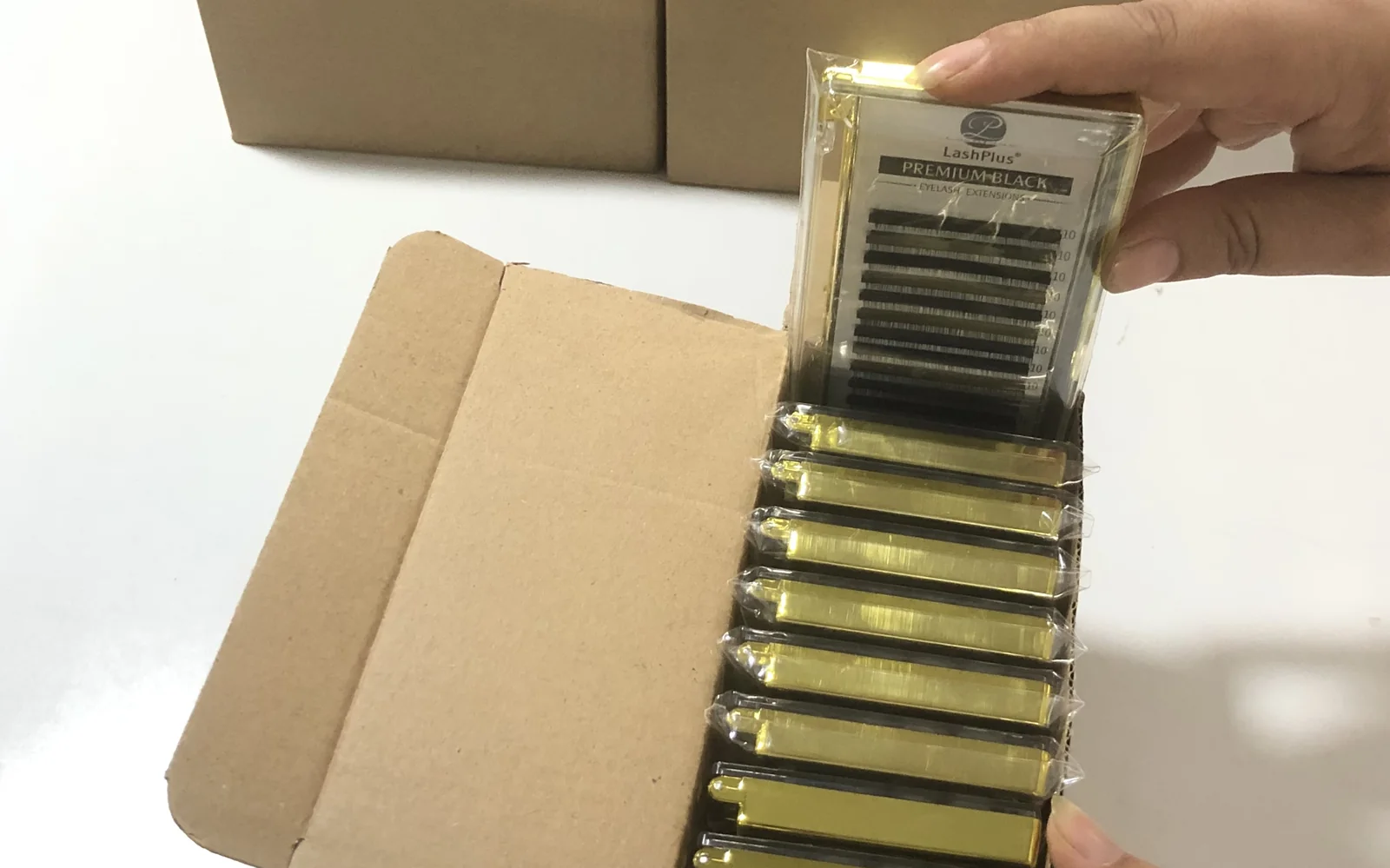 Finished Premium Black trays going into their inner box beside plain kraft boxes